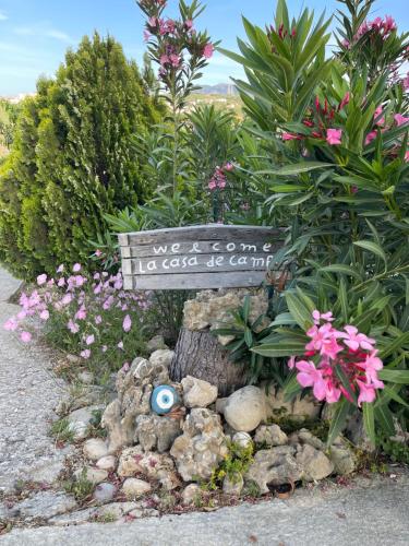 a garden with a sign and flowers and plants at La casa de campo in Heraklio Town