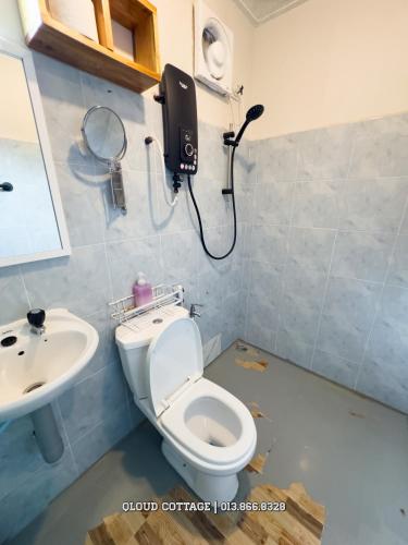 a bathroom with a toilet and a sink at Qloud Cottage Kundasang in Ranau