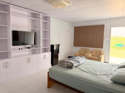 a bedroom with a bed and a flat screen tv at Dhan Valley Guest House in Bhaun