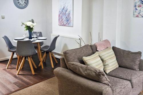 a living room with a couch and a table with chairs at Howells Cottage in Monmouth