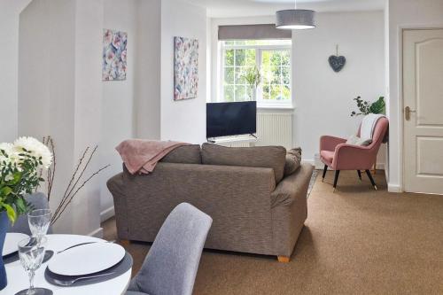 a living room with a couch and a tv at Howells Cottage in Monmouth