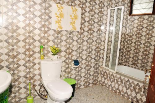a bathroom with a toilet and a sink and a tub at Luxury Apartments in Kumasi