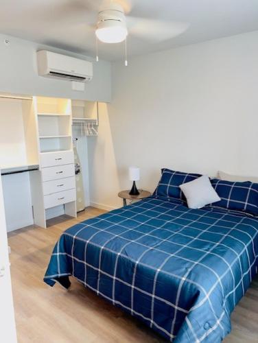 una camera con letto blu e una cucina di Marble Flatz a Marble Falls