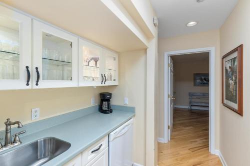 a kitchen with white cabinets and a sink at Naples North in Fennville