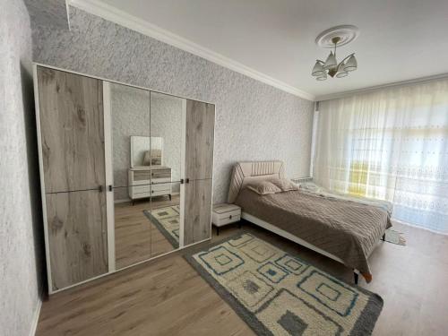 a bedroom with a bed and a mirrored cabinet at Caspian Mirvari 2 in Sumqayıt