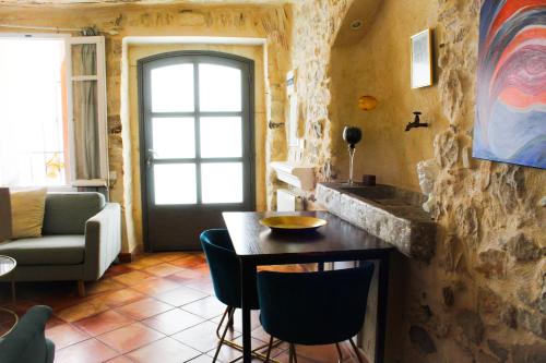 une cuisine avec une table et des chaises dans une pièce dans l'établissement La Tour du Vidourle, à Lecques