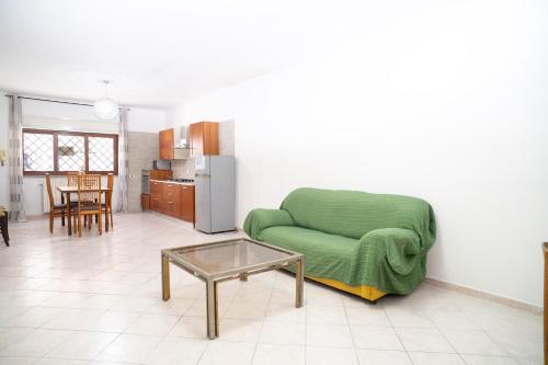 a living room with a green couch and a table at Elegante per 6 a due passi dalla spiaggia in Nettuno
