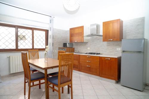 a kitchen with a table and chairs and a refrigerator at Elegante per 6 a due passi dalla spiaggia in Nettuno