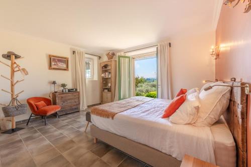 une chambre avec un grand lit et une fenêtre dans l'établissement Le Mas Elaïa, votre havre familial avec piscine privée, à Eyragues