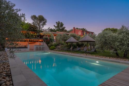 une piscine dans l'arrière-cour d'une maison dans l'établissement Le Mas Elaïa, votre havre familial avec piscine privée, à Eyragues
