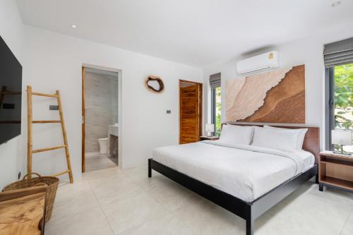 1 dormitorio con cama, escalera y baño en Reve Samui Luxe Seafront Residence with Panoramic Views, en Ban Bang Po