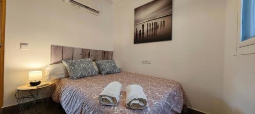 a bedroom with a bed with two towels on it at Casa del Castillo by Naturadrada in La Adrada