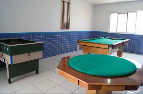 a room with two ping pong tables and a green circle at Flatguarapari in Guarapari