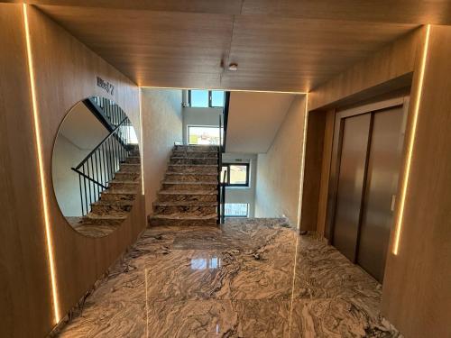 a hallway of a building with a staircase and a mirror at Luxe Apartment - NEO TOWER in Suceava