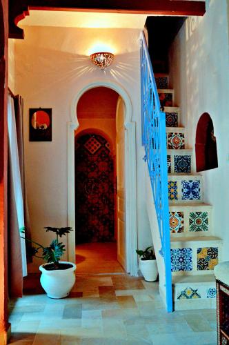 a hallway with a staircase and a door with vases at Dar Shams Riad Medina de Sousse in Sousse
