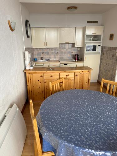 une cuisine avec une table et un comptoir dans l'établissement La Muande Appartement famille, à Orcières