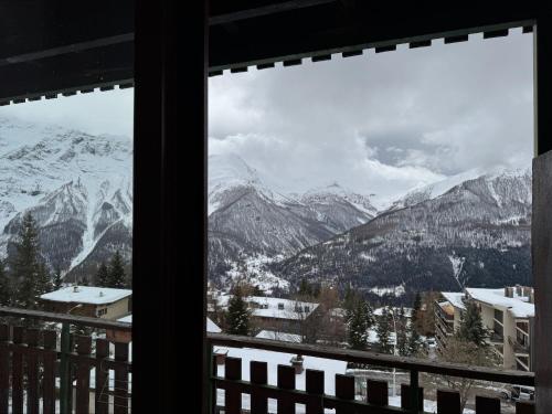 Elle offre une vue sur une chaîne de montagnes enneigée depuis sa fenêtre. dans l'établissement La Muande Appartement famille, à Orcières