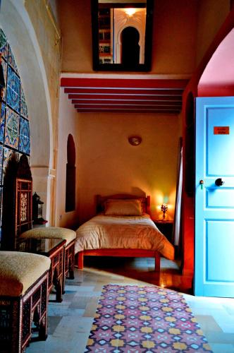 a bedroom with a bed in the corner of a room at Dar Shams Riad Medina de Sousse in Sousse