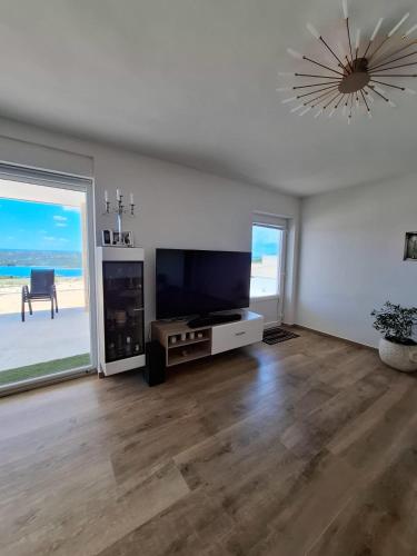 a living room with a flat screen tv and a large window at House of Freedom in Kruševo