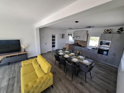 a living room with a table and a yellow couch at House of Freedom in Kruševo