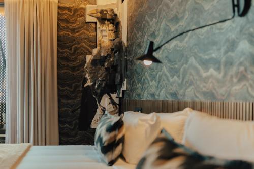 a bedroom with a bed with a blue wall at Hotel Leiriartem by Grupo Quinta dos Lagos in Leiria