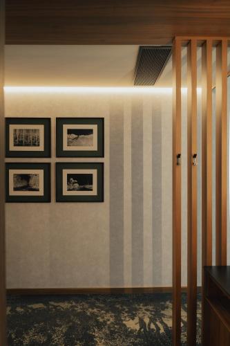 a room with three framed pictures on a wall at Hotel Leiriartem by Grupo Quinta dos Lagos in Leiria