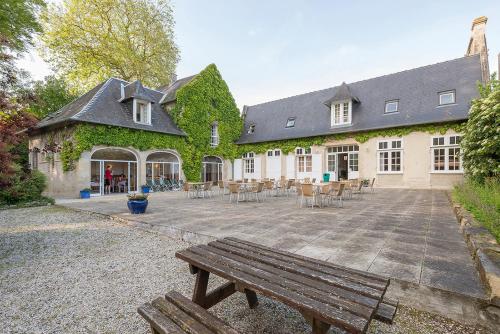 a building with a bench in front of it at Château Baffy in Colombiers-sur-Seulles