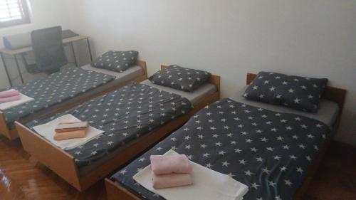 a room with two beds and a table with a cake at Apartman Lastva in Lastva