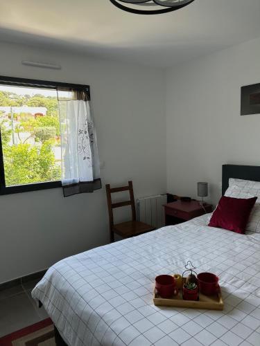 une chambre avec un lit avec deux conteneurs rouges dessus dans l'établissement Le Lavandin - classé 3 étoiles, à Sète