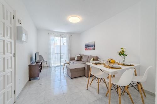a white living room with a table and a couch at La Punta in Alcalá