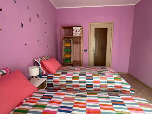 a bedroom with a bed and purple walls at Casa di Amalia 14 in Biella