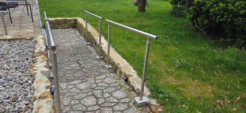 a stone walkway with metal railings on a lawn at Accesible countryside retreat with private garden and all modern facilities in Chassenon
