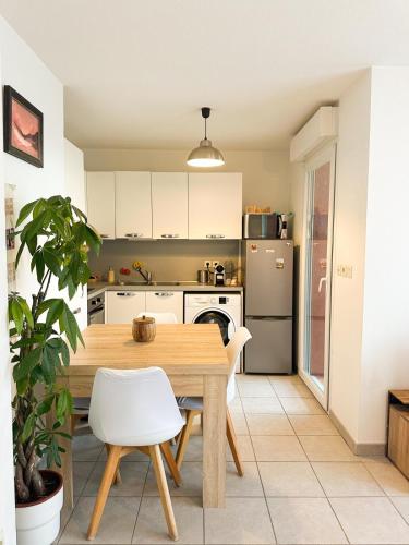 une cuisine avec une table en bois et des appareils électroménagers blancs dans l'établissement Appartement 2 pièces, à Saint-Laurent-du-Var