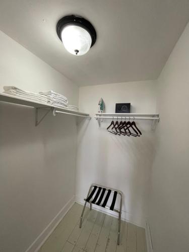 a room with a white wall with shelves and a bench at West End Inn in West End