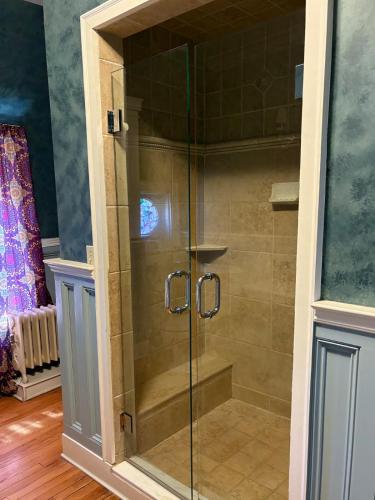 a shower with a glass door in a bathroom at The Converse Castle in Norwich