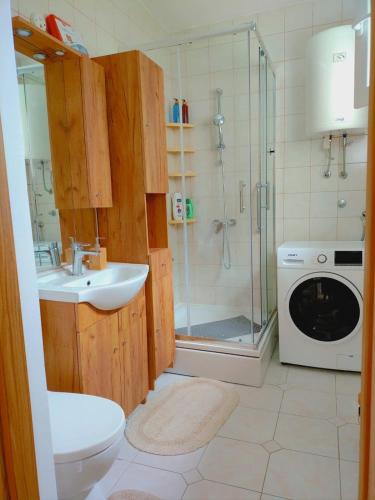 a bathroom with a sink and a washing machine at ZIA -Kuća za odmor in Vrbanja