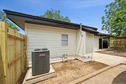 a house with a trash can next to a fence at Comfortable 2-Bedroom Rental in Bridge City in Bridge City