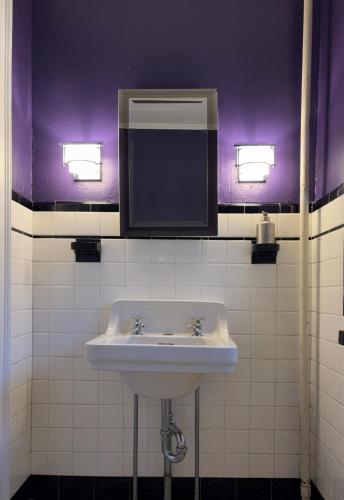 a bathroom with a white sink and a mirror at The Converse Castle in Norwich