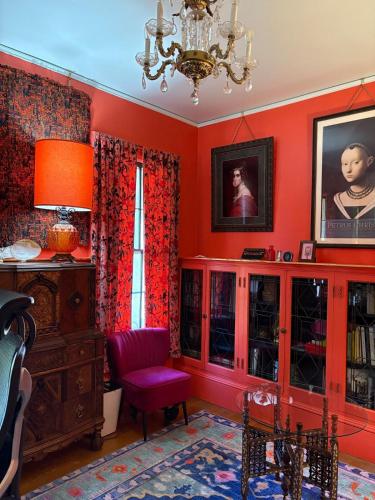 a living room with red walls and a chandelier at The Converse Castle in Norwich