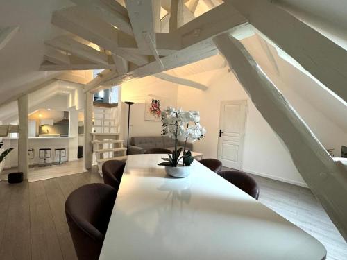a living room with a white table and chairs at Le Duplex de Villeneuve in Villeneuve-sur-Yonne