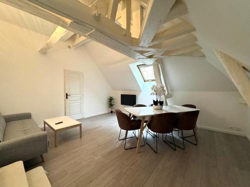 a living room with a table and chairs and a couch at Le Duplex de Villeneuve in Villeneuve-sur-Yonne