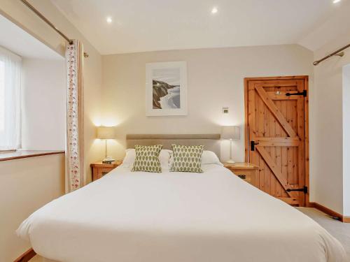 a bedroom with a white bed and a wooden door at 1 Bed in Launceston BRLON in Launceston