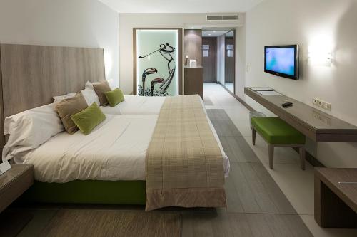 a bedroom with a bed and a desk and a television at Golf Royal Hotel in Tunis