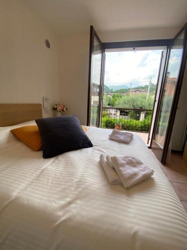 a large white bed with two towels on top of it at Gardasweethome in Garda