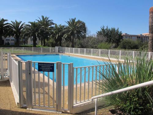 un portail menant à une piscine avec des palmiers dans l'établissement ANTIBES, 85 m2, ground floor, large wood terrace, à Antibes