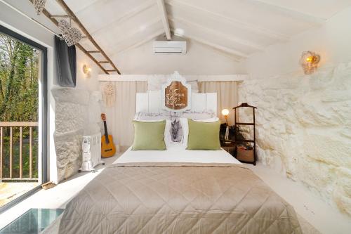 バイアンにあるWHome Riverfront Retreat with Exclusive Waterfall Viewsの石壁のベッドルーム1室(大型ベッド1台付)