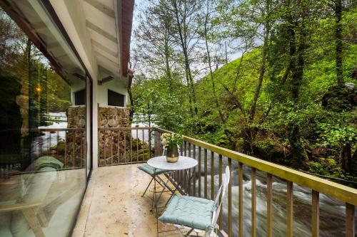 バイアンにあるWHome Riverfront Retreat with Exclusive Waterfall Viewsのバルコニーにテーブルと椅子が置かれたパティオ