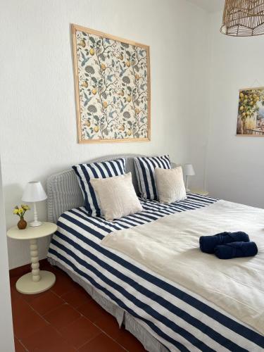 - une chambre avec un grand lit aux rayures bleues et blanches dans l'établissement Le Sicile, à Lespignan