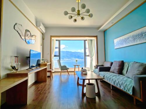 a living room with a couch and a tv at 大理顾里海景别墅Dali Guli Sea View Villa Hotel in Dali