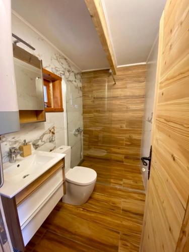 a bathroom with a white toilet and a sink at Zaovinska idila in Bjeluša